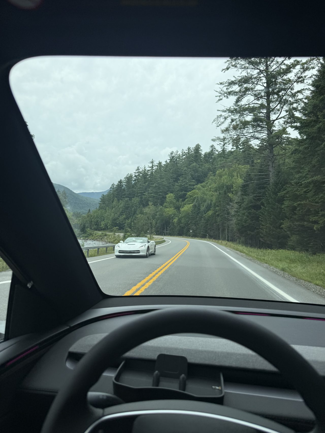 透过挡风玻璃看到的山路与迎面驶来的白色敞篷跑车