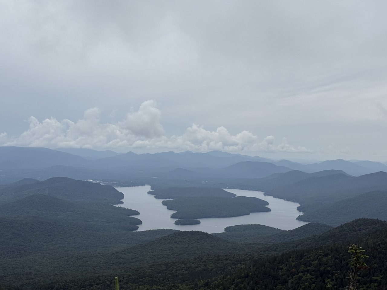 俯瞰普莱西德湖，两座森林覆盖的大岛周围环绕着雾蓝色群山