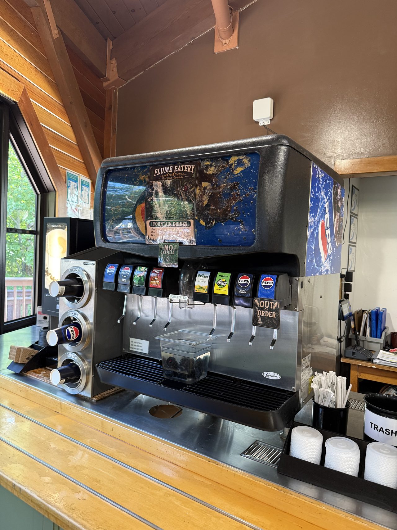 A Pepsi fountain drink machine with an out of order sign in a wooden visitor center.